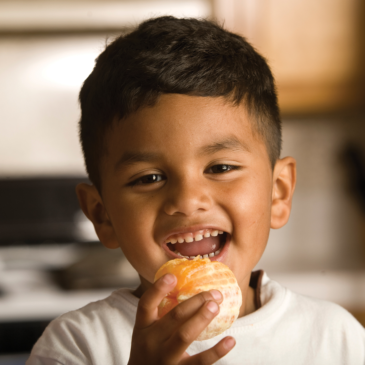 Un niño sonriente con una naranja pelada