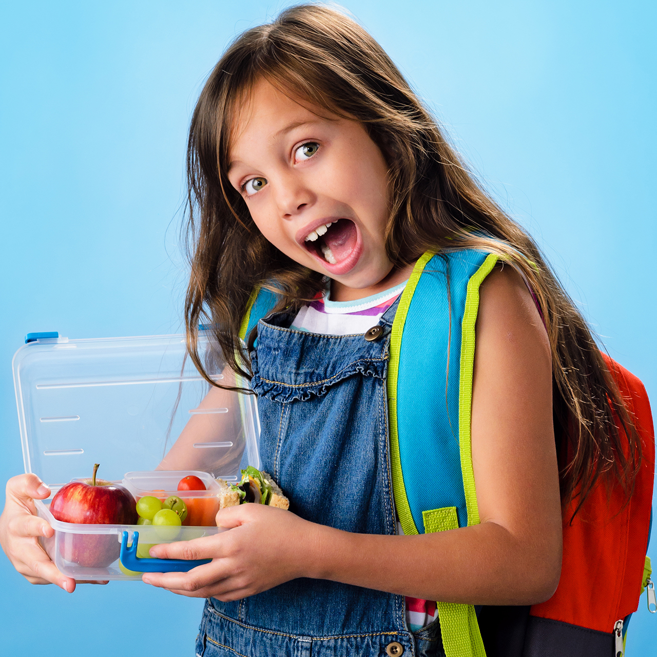 Girl with lunch box packed with fruit for school