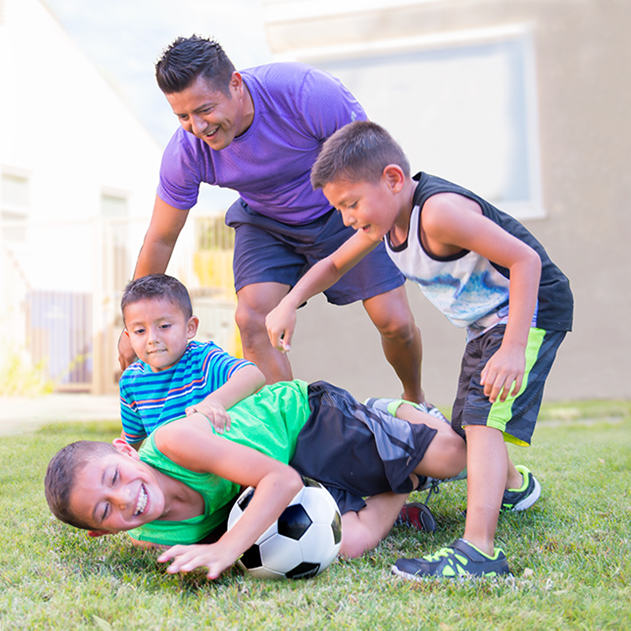 Papá con hijos jugando fútbol