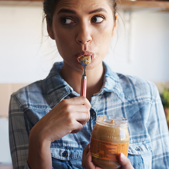 Photo of woman eating nut butter.